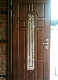 Дверь с ковкой и стеклом в загородном доме